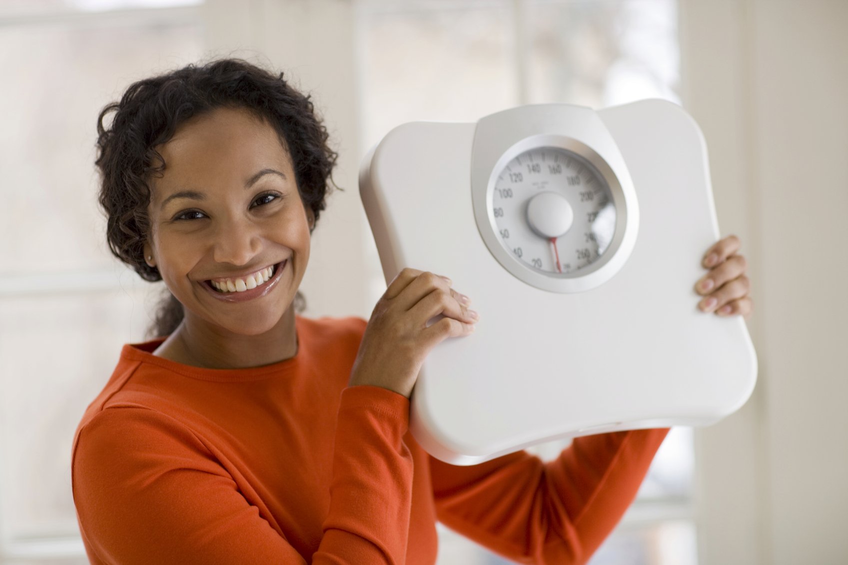 Beautiful African American woman holding scale