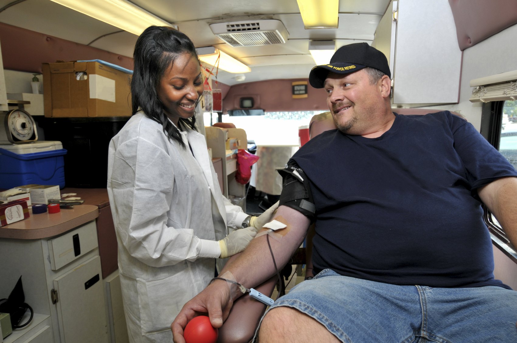 a doctor collects blood from a donor in a mobile blood bank