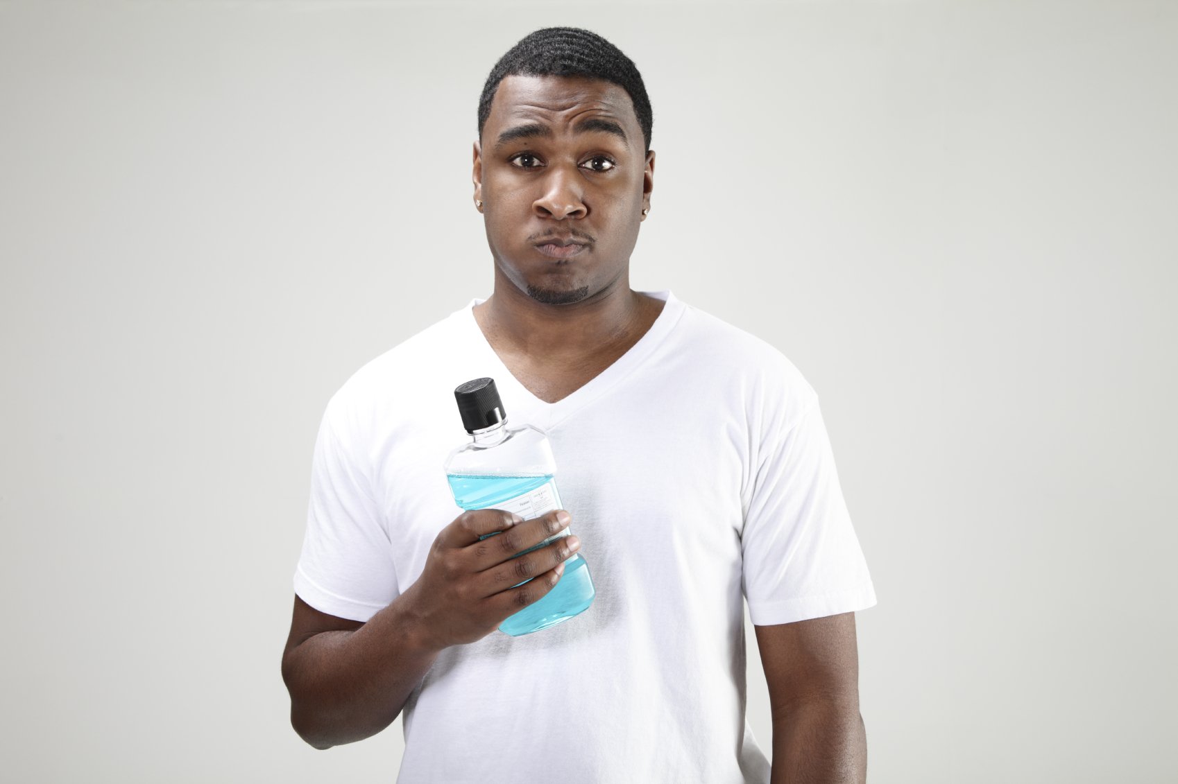 a man rinses his mouth out with mouthwash