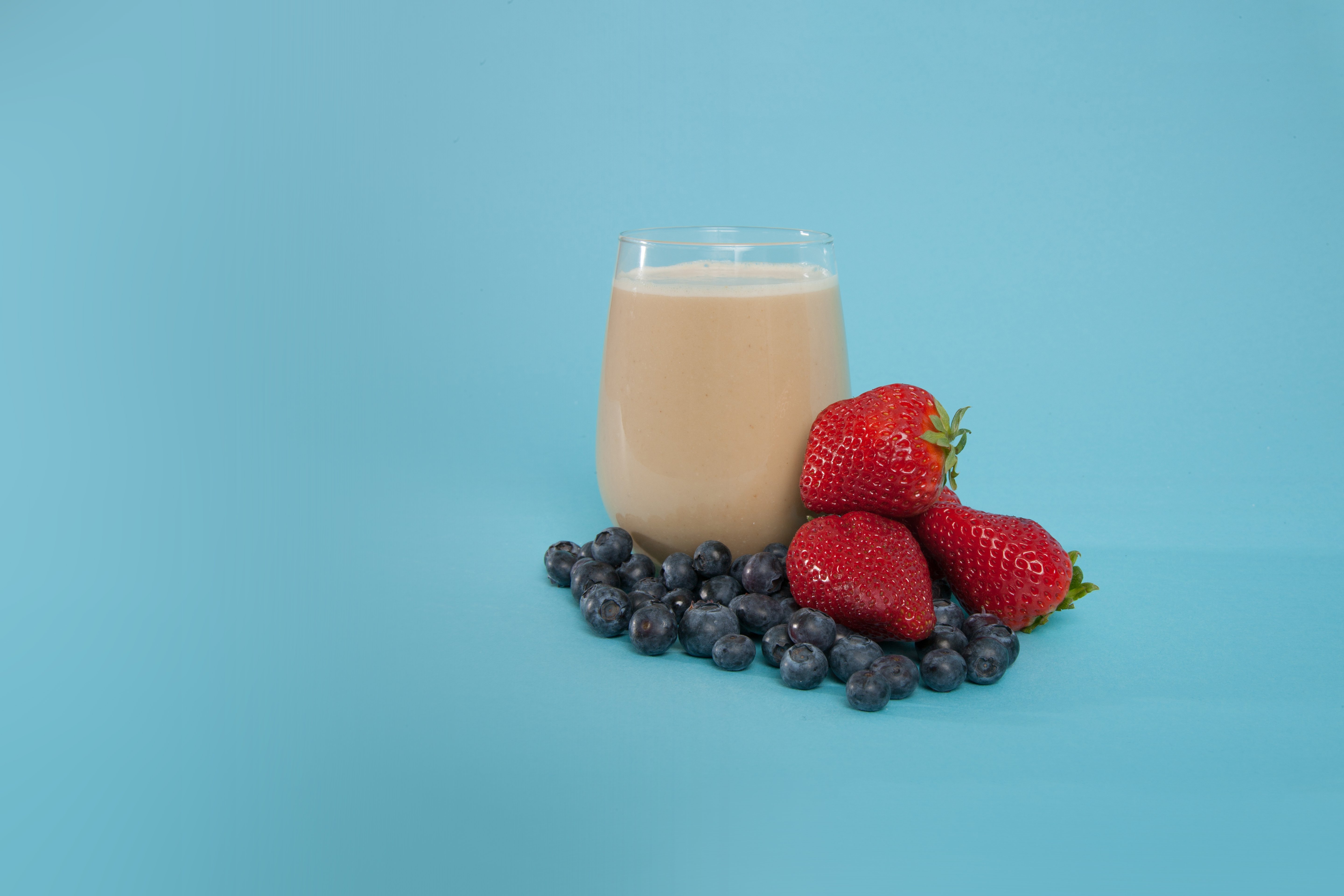 a glass of soylent and berries