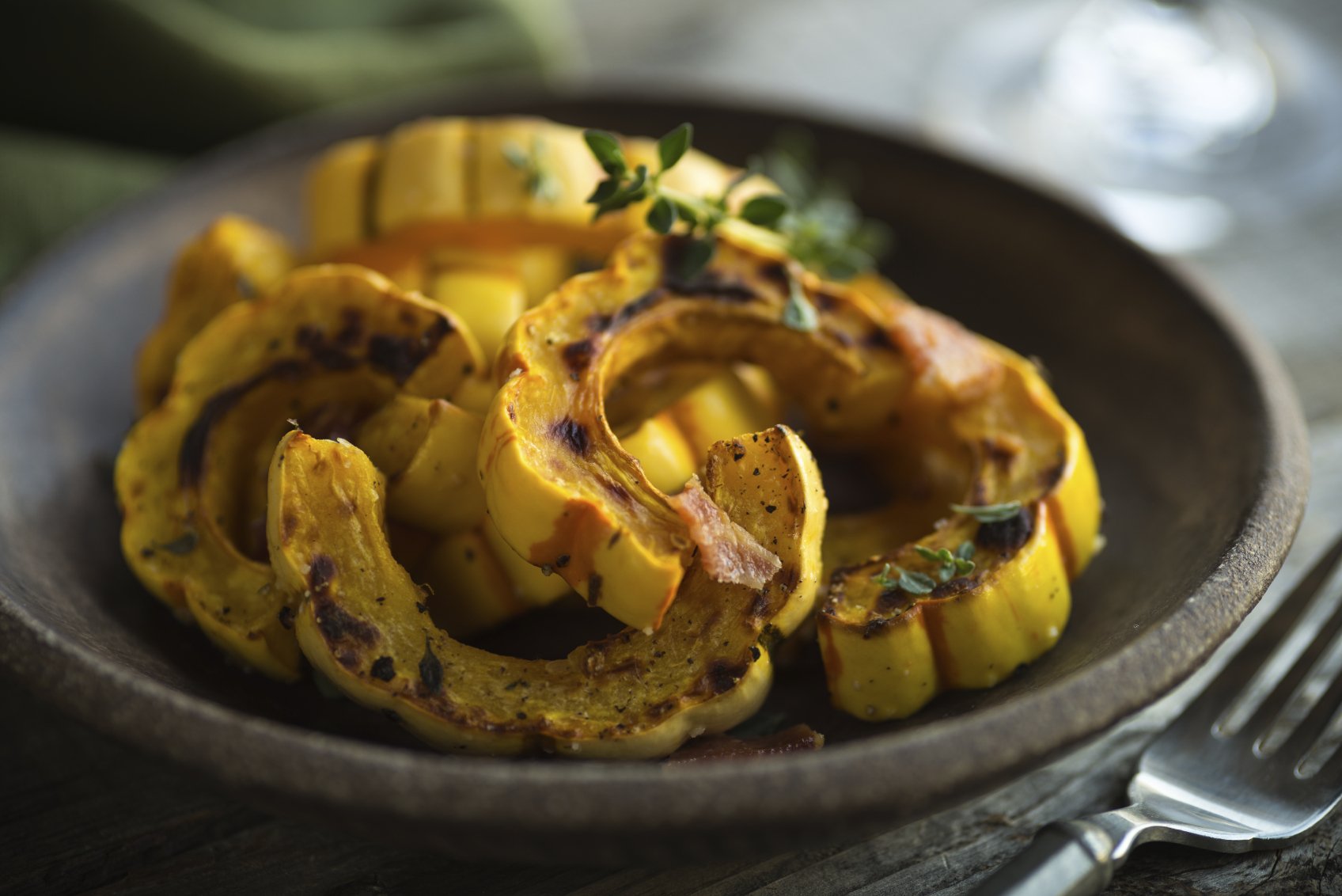 Plate with freshly roasted delicata squash and herbs